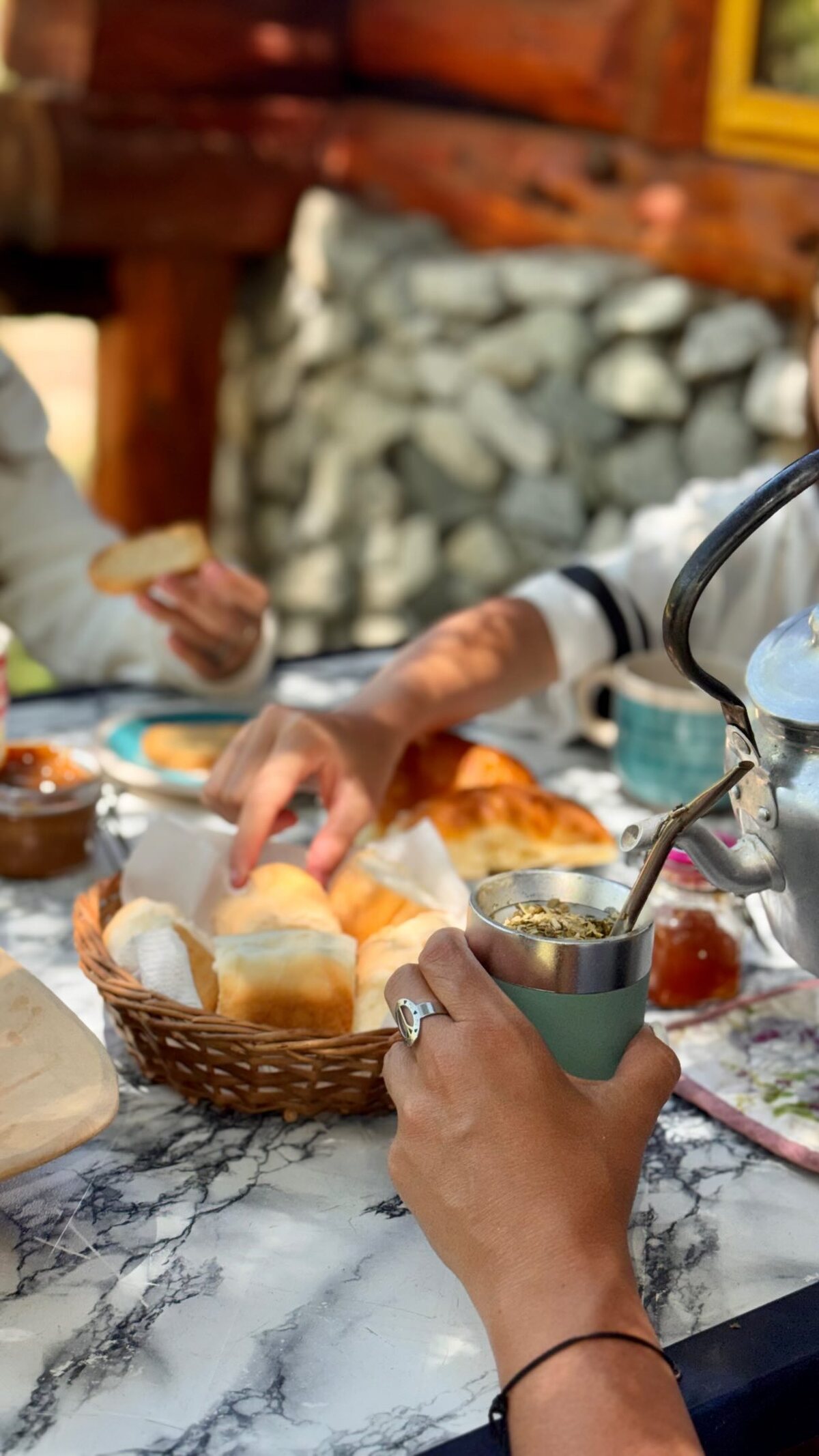 Mesa de desayuno con panes caseros en una panera y té